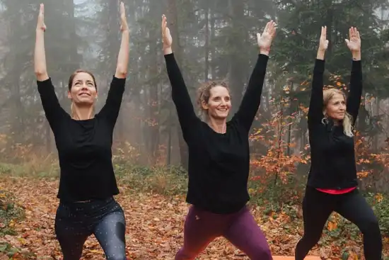 drei Damen im Wald die eine Yogapose machen
